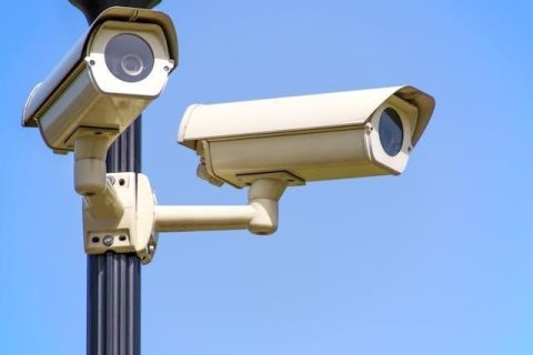 Two white cameras on a black pole