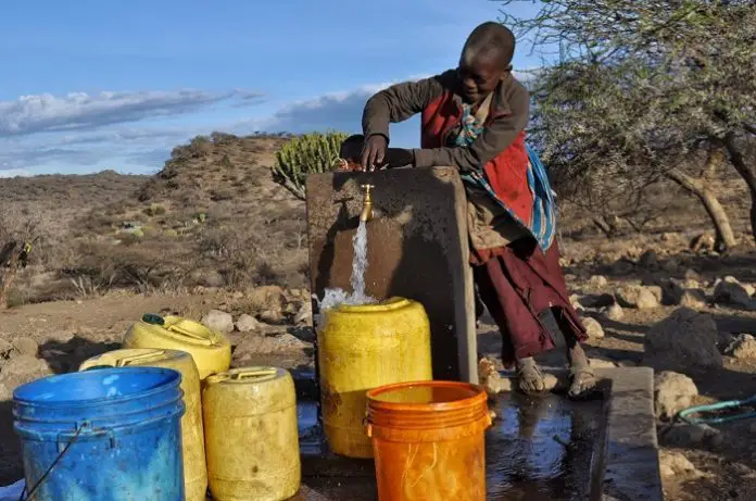 Kinder sammeln Wasser in Uwiro Village, Tansania.