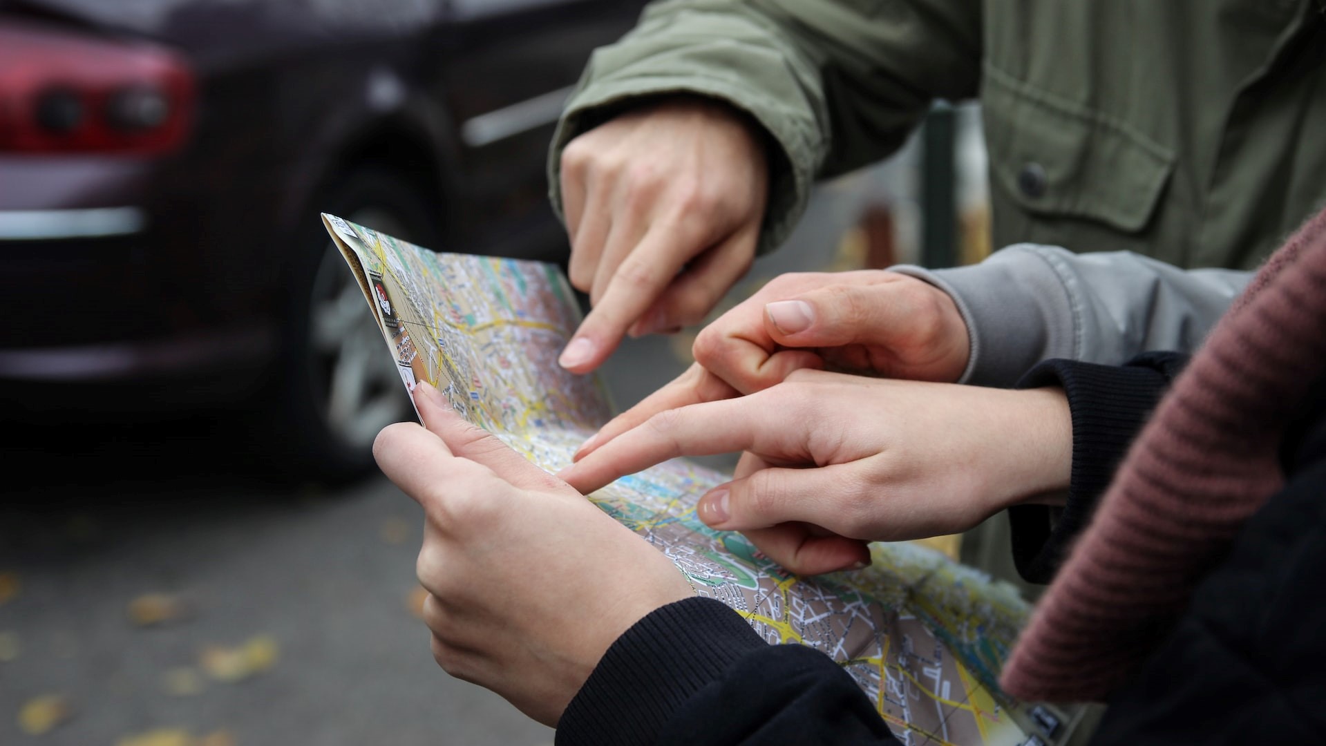 People pointing to a location on a paper map.
