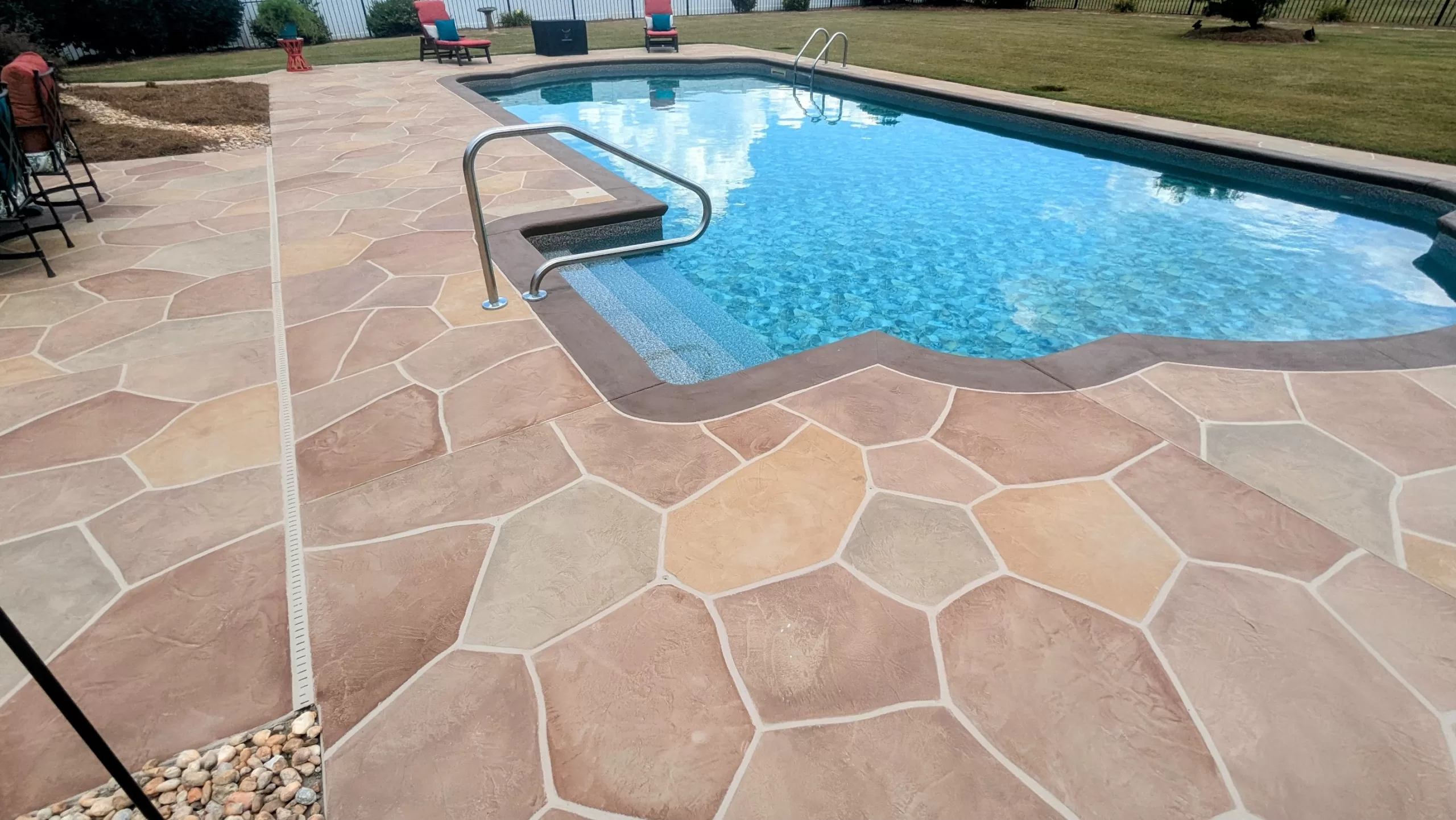 concrete overlay pool deck with pool in backyard