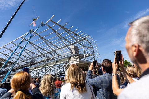 Amway Stadium reaches a major milestone as crews raise the final steel beam, keeping the $175M Grand Rapids project on track for 2027.