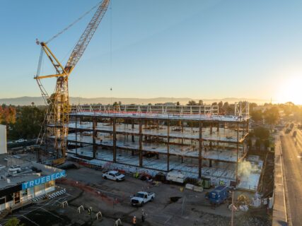 The project celebrated its structural steel topping-out ceremony, marking the completion of the framework for the four-story, 64,000-square-foot facility.