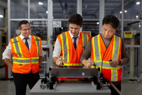 Former Prime Minister Justin Trudeau (center) and Danies HS Lee (right) signing their names on the first EV battery module produced at the NextStar Energy plant.